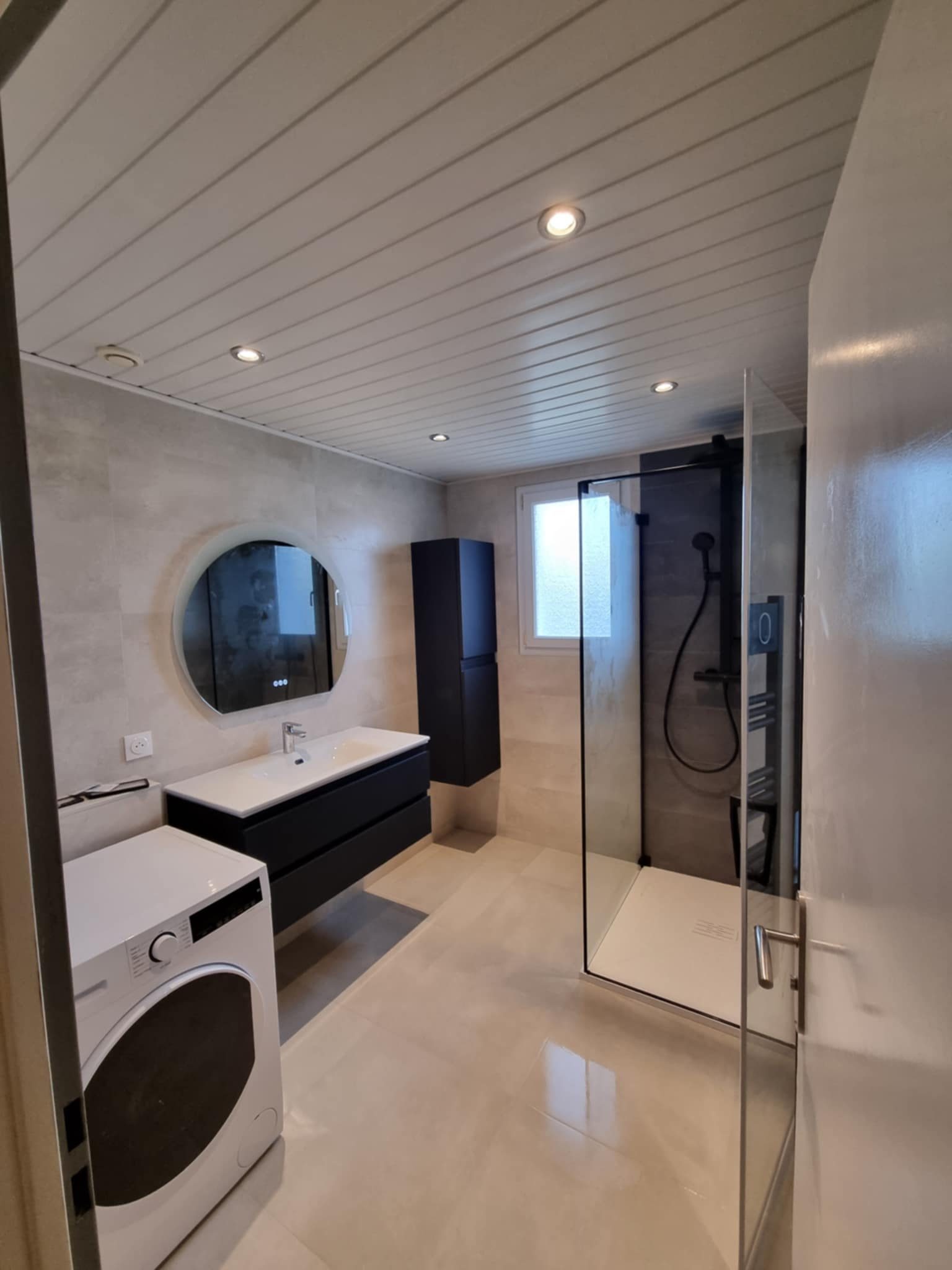 Grande salle de bains claire avec paroi de douche noire