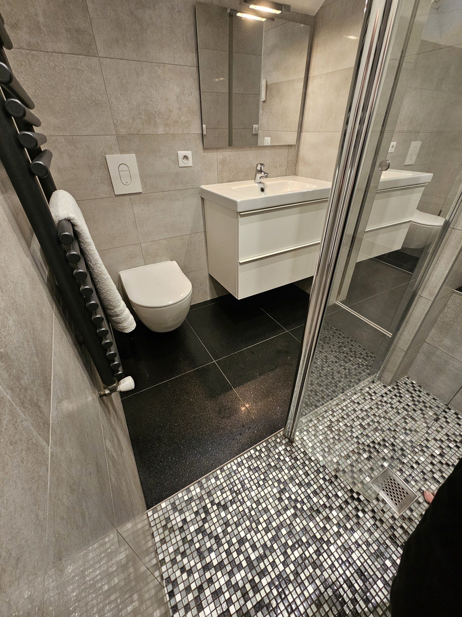 Sol de douche en mosaïque argentée et sol en granit noir