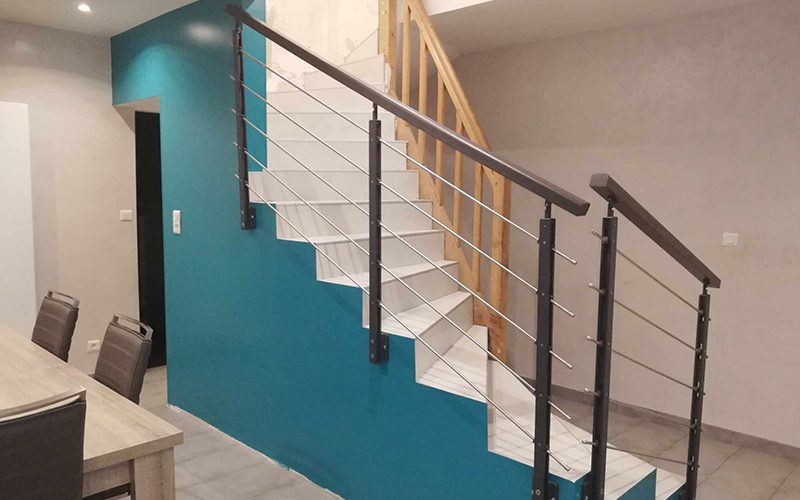 Escalier carrelé blanc devant un mur bleu canard